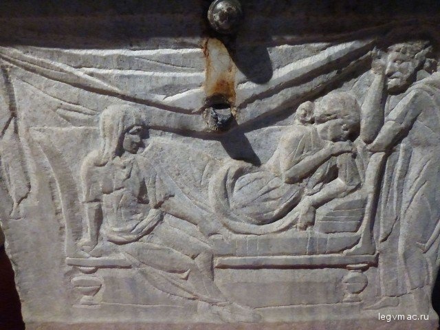 Неглубокий рельеф на саркофаге показывает скорбь отца и матери у ложа заснувшей смертным сном юной дочери.